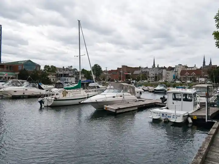 Sailboats and pleasure boats in Brockville municipal harbour with downtown in the background