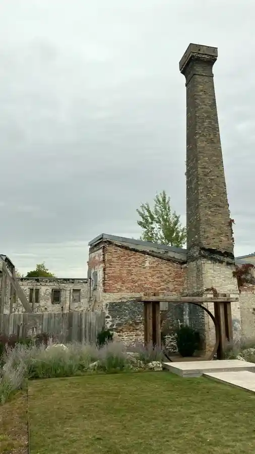 Standing brick chimney and stone industrial ruins near the Elora Mill complex