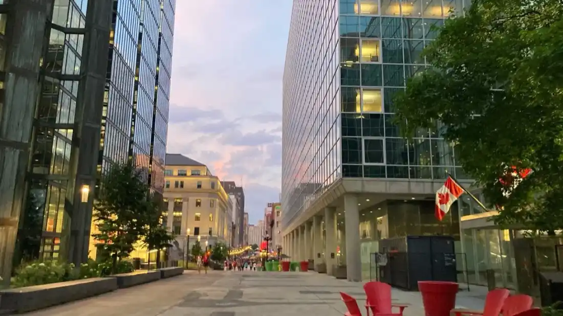 Rue piétonne au centre-ville d’Ottawa au crépuscule avec drapeaux canadiens