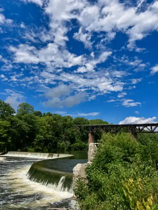 Curved low-head Penman's Dam beneath a blue, cloud-filled sky