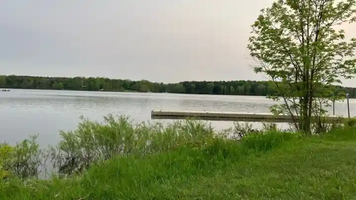 Dock extending into Wildwood Reservoir beside a grassy shore